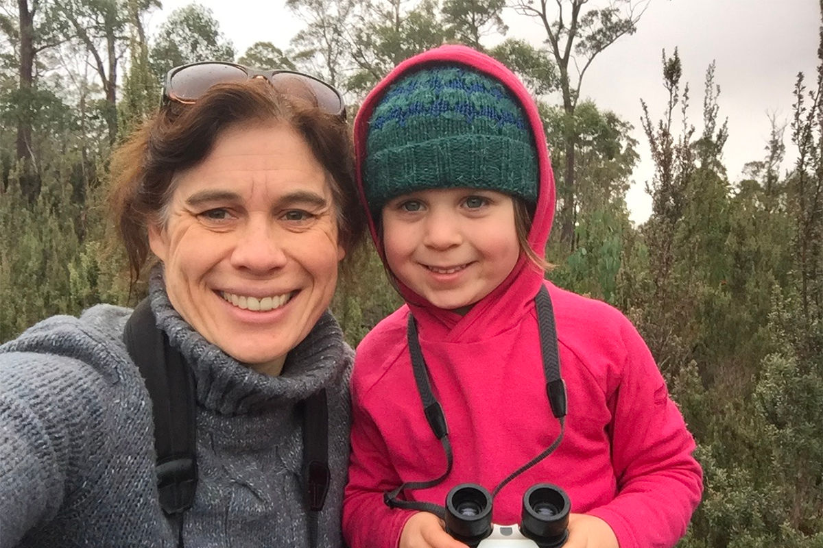 A mother and young daughter, warmly dressed, pose in front of a remote heathland area after a Where? Where? Wedgie! 10 minute survey. The daughter is holding a pair of binoculars and both look very happy. Photo: Kate Thorn.